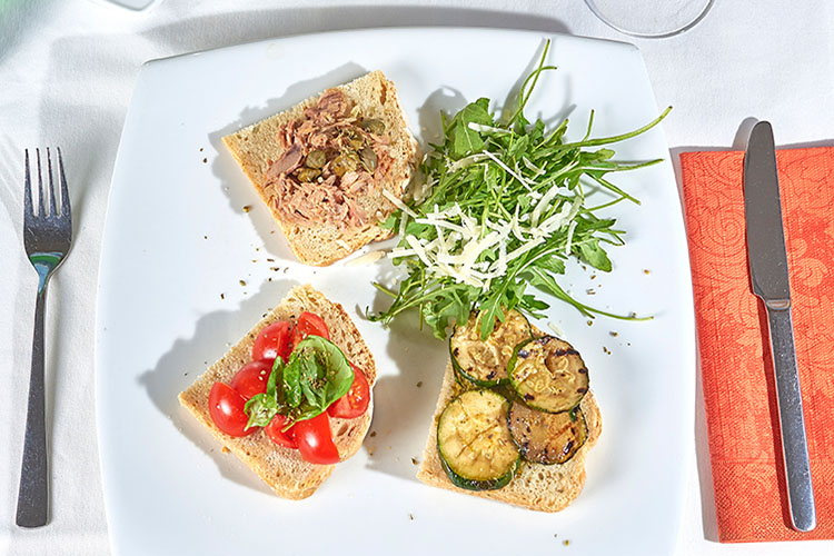 Bruschette Misto, gebackenes italienisches Weißbrot mit Tomate-Knoblauch, Zucchini, Thunfisch-Kapern