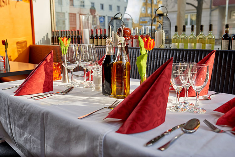 Festlich gedeckter Tisch, weiße Tischdecke mit roten Servietten